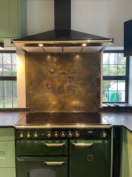 Patinated brass splashback behind a range cooker